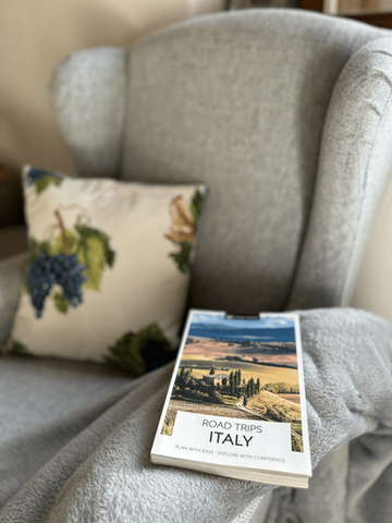 Road trips of Italy Book resting on the arm of a comfy chair