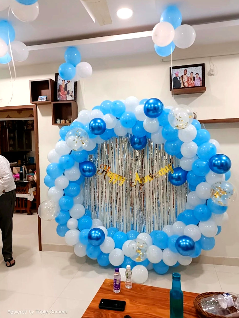 Baby shower decoration with blue and white balloons with a shiny backdrop.