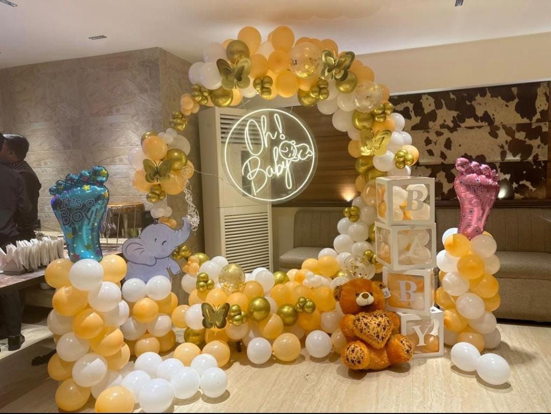 Baby shower with balloons, decorations, and an illuminated 'Oh Baby' sign. Decor By Little Loves