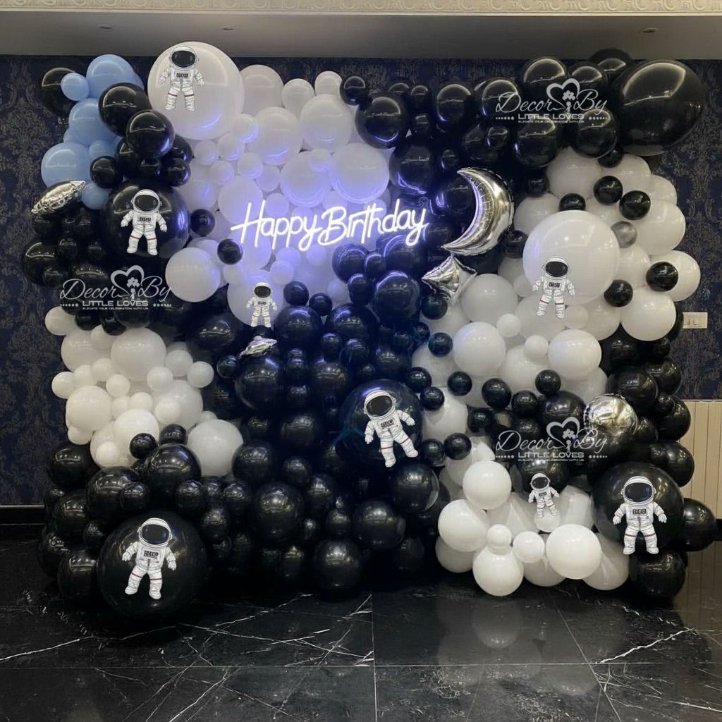 Birthday wall decorated with black, white balloons and Happy Birthday neon sign. Black and White Space Themed Decor