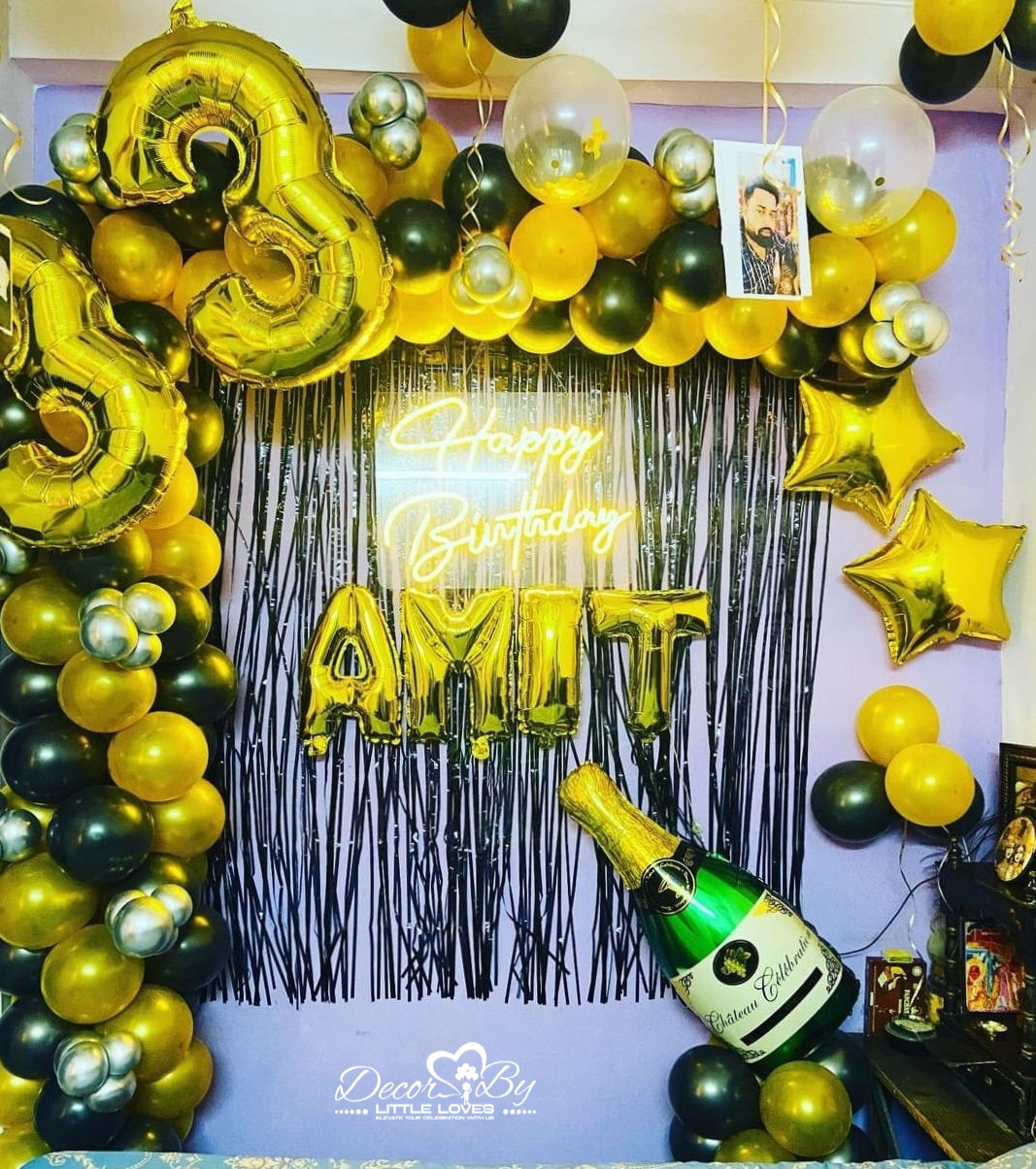 Golden balloons, "Happy Birthday Amit" text, and champagne bottle decoration Decor By Little Loves