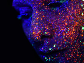 Face with glitter and a black background.