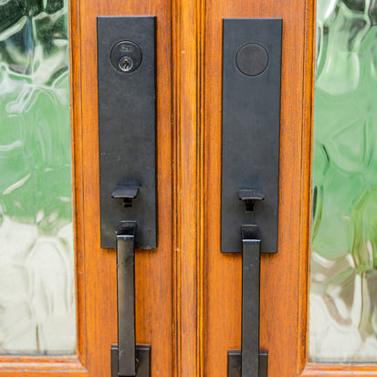 Black modern door handles on wooden double doors