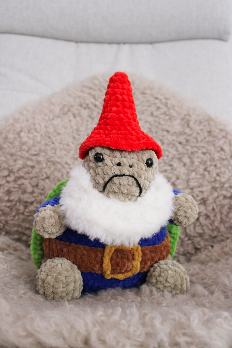 Thumbnail: A grumpy gnome turtle, sitting on a faux fur rug, on a chair.