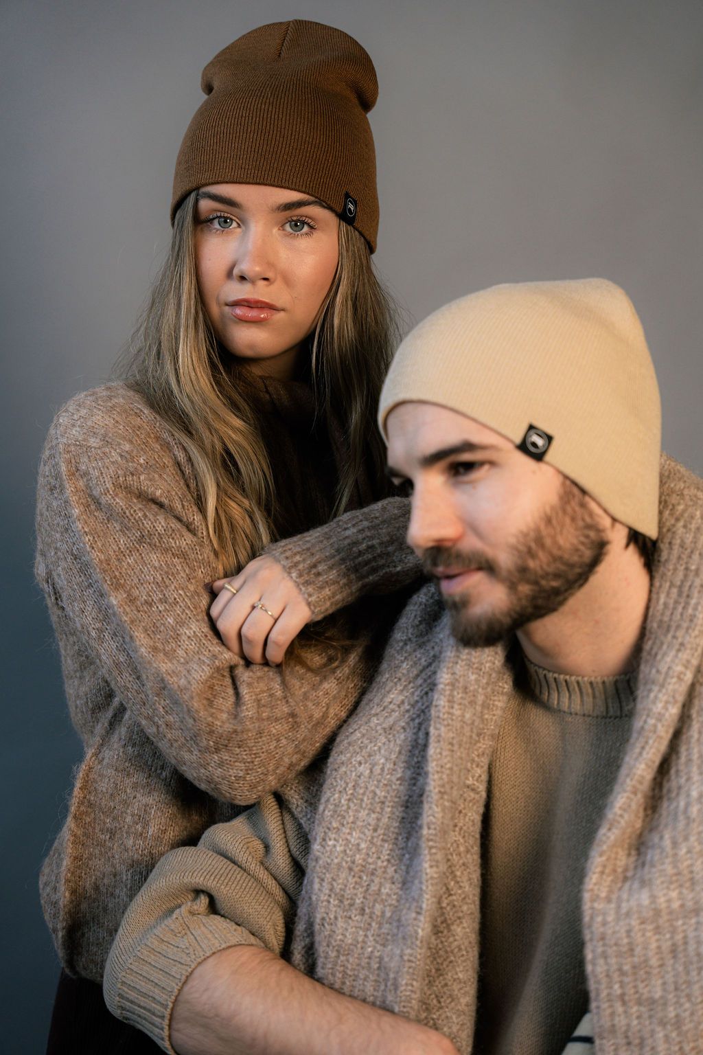 Two people wearing brown and cream Revony beanies
