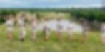 A group of Bushwise students standing in front of a vast dam in the South African Lowveld.