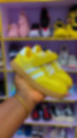 Yellow child sneakers with white stripes and velcro