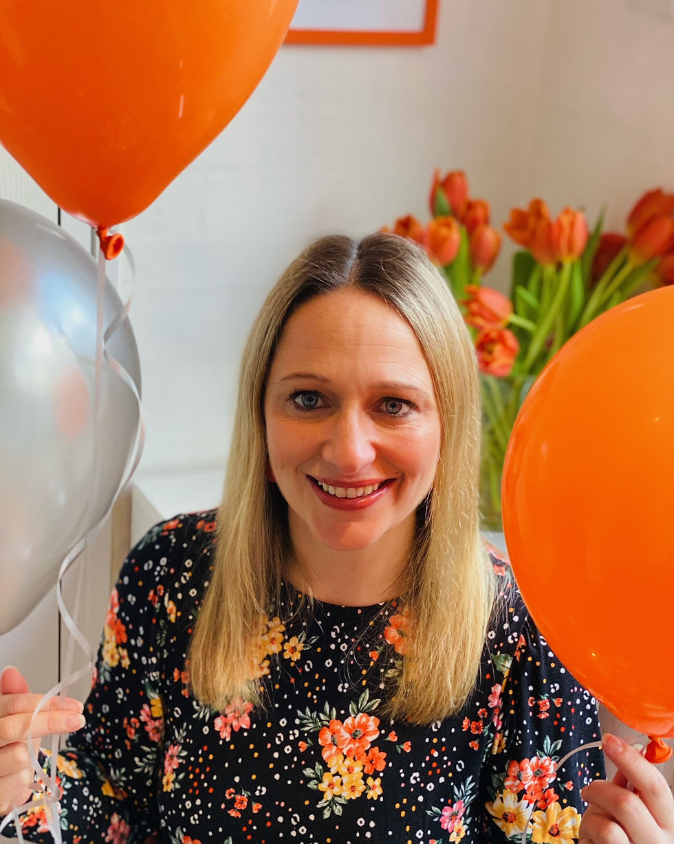 Nat Sharp holding orange and silver balloons
