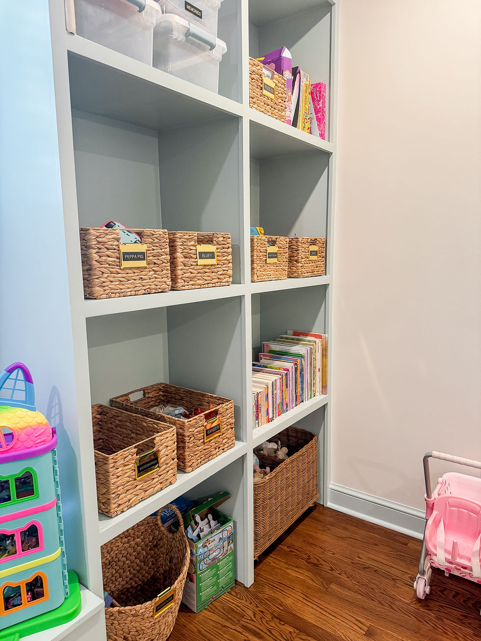 Organized shelves with wicker baskets, books, and toys in a light-colored playroom.
