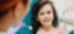 Lovely little kid smiling while talking with the pediatric dentist