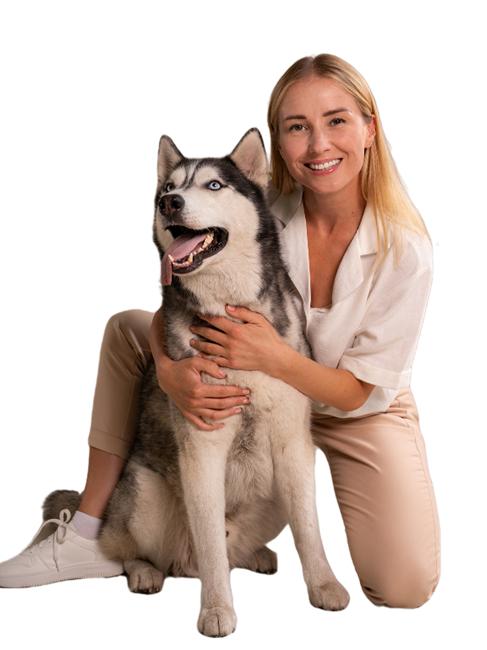 Smiling woman kneeling with husky dog