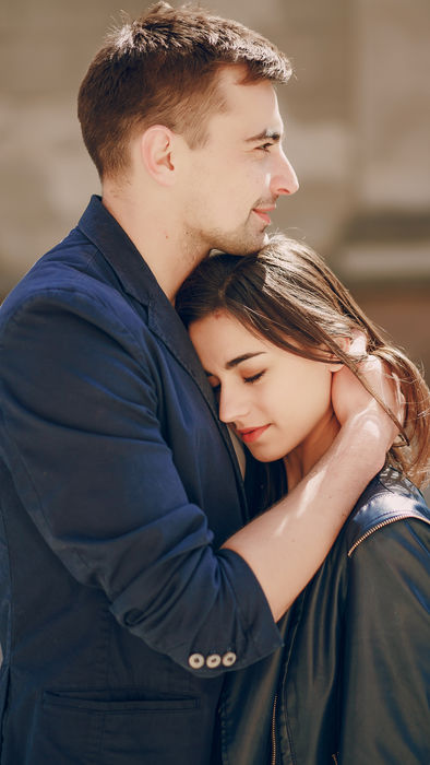 Man embracing woman, her head on his shoulder