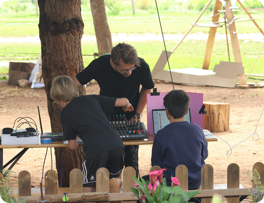 Students learning audio mixing outdoors at Montessori.