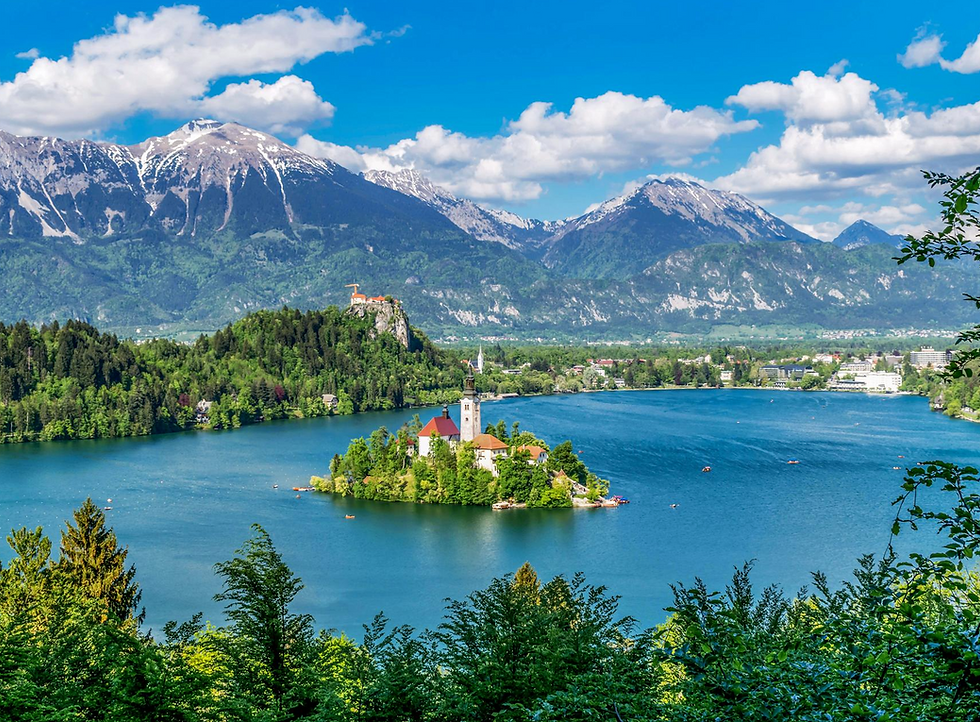 Church on Bled Island with snow-capped mountains in Slovenia