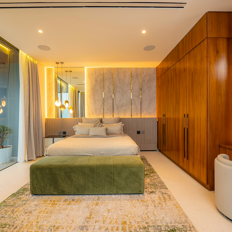 Luxurious modern bedroom with large bed, green velvet bench, and wooden wardrobe.