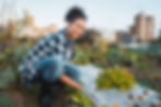 A happy woman sits in a city park after attending at The Wellbeing & Recovery Collective meeting.