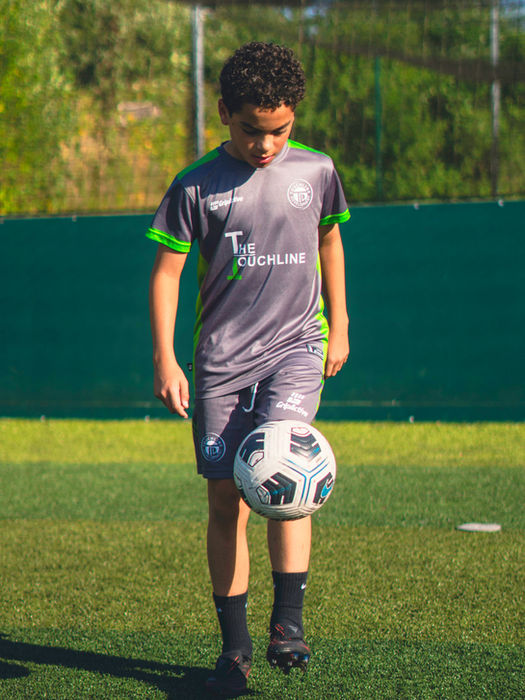 Young player practicing ball control and kicking technique during a football training session