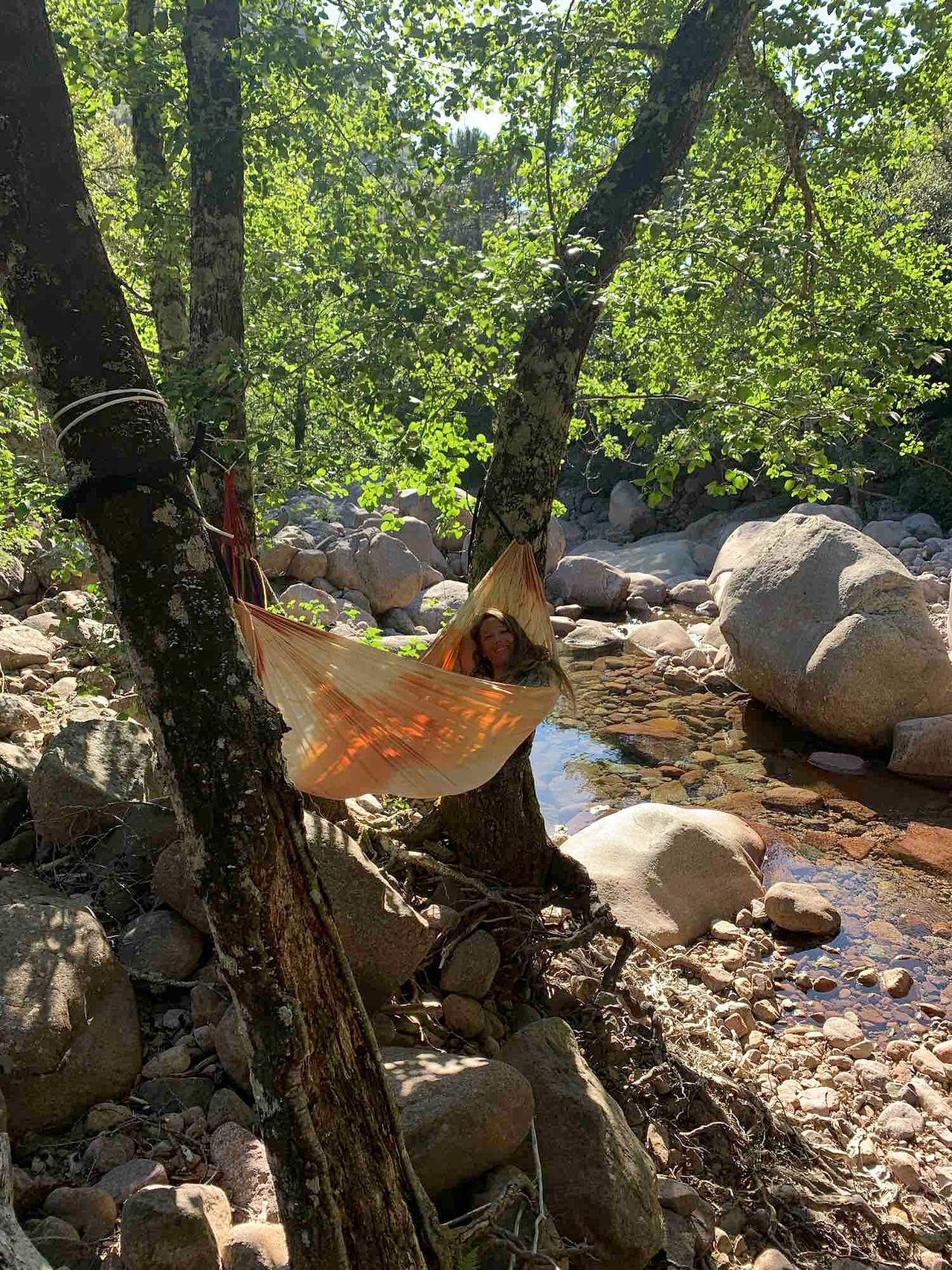 la foret de bonifatto : une piscine natuelle et une personne dans un hamac