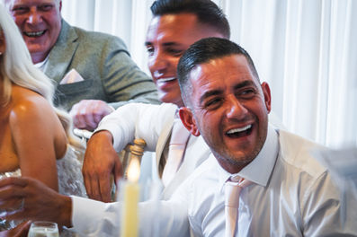 Groom's brother laughing during wedding speeches