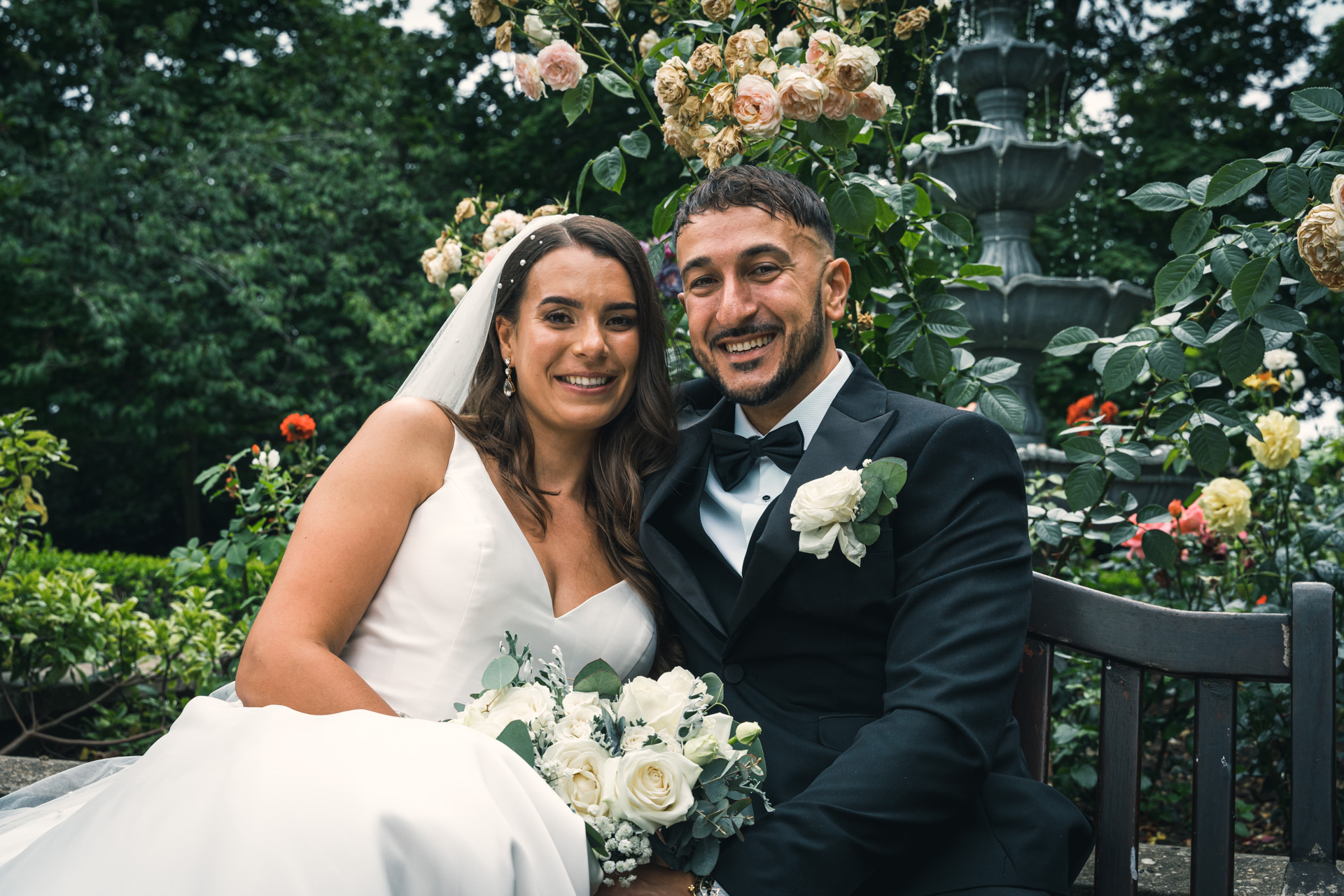 Portrait of newlyweds sitting down on a background of a garden