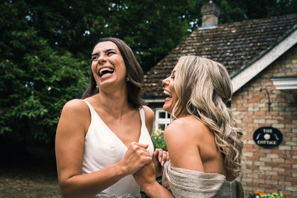 Bride and bridesmaid laughing