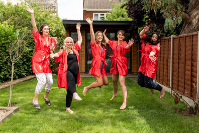 Bridesmaid in their dressing gowns jumping up in a funny photo at the morning preparations.