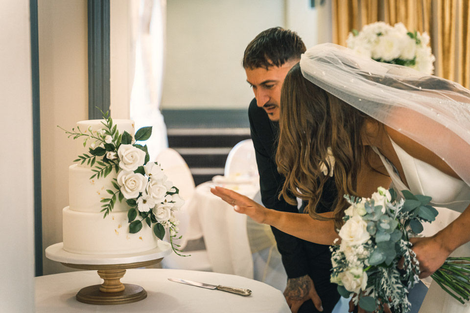 Bride and groom checking out their wedding cake before guests arrive.