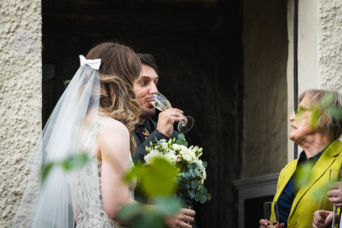 Groom sipping champagne, just heard a funny story.