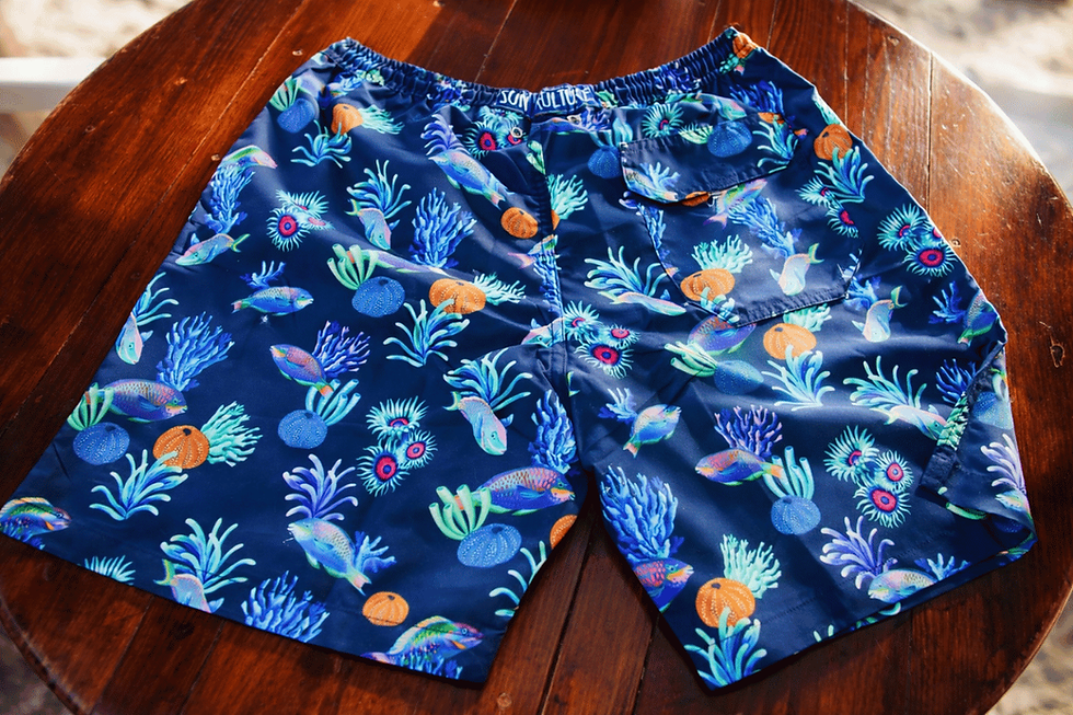Sun Kulture Parrotfish Design Swim Shorts/Swim Trunks on a Table.