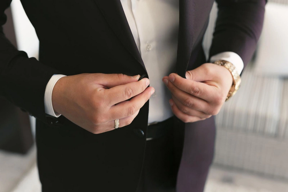 man buttoning his jacket