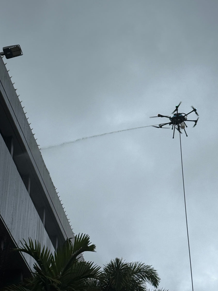 Drone spraying beside an elevated exterior