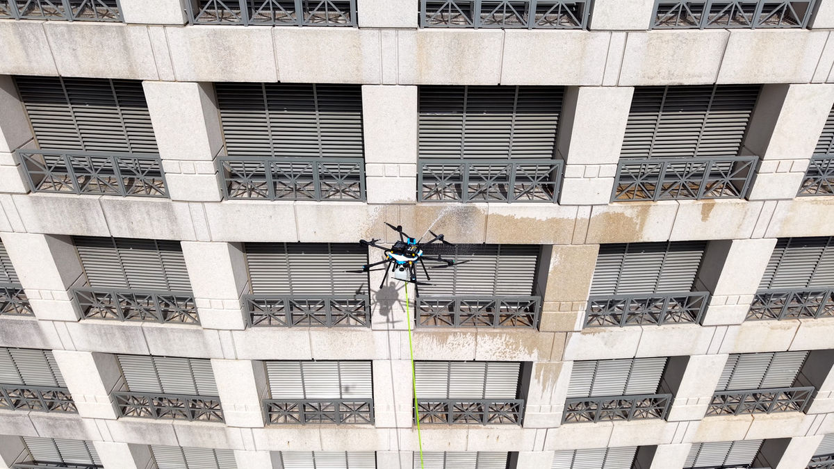 Drone cleaning beside balcony railings