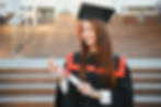 Joven con diploma en mano en evento académico.
