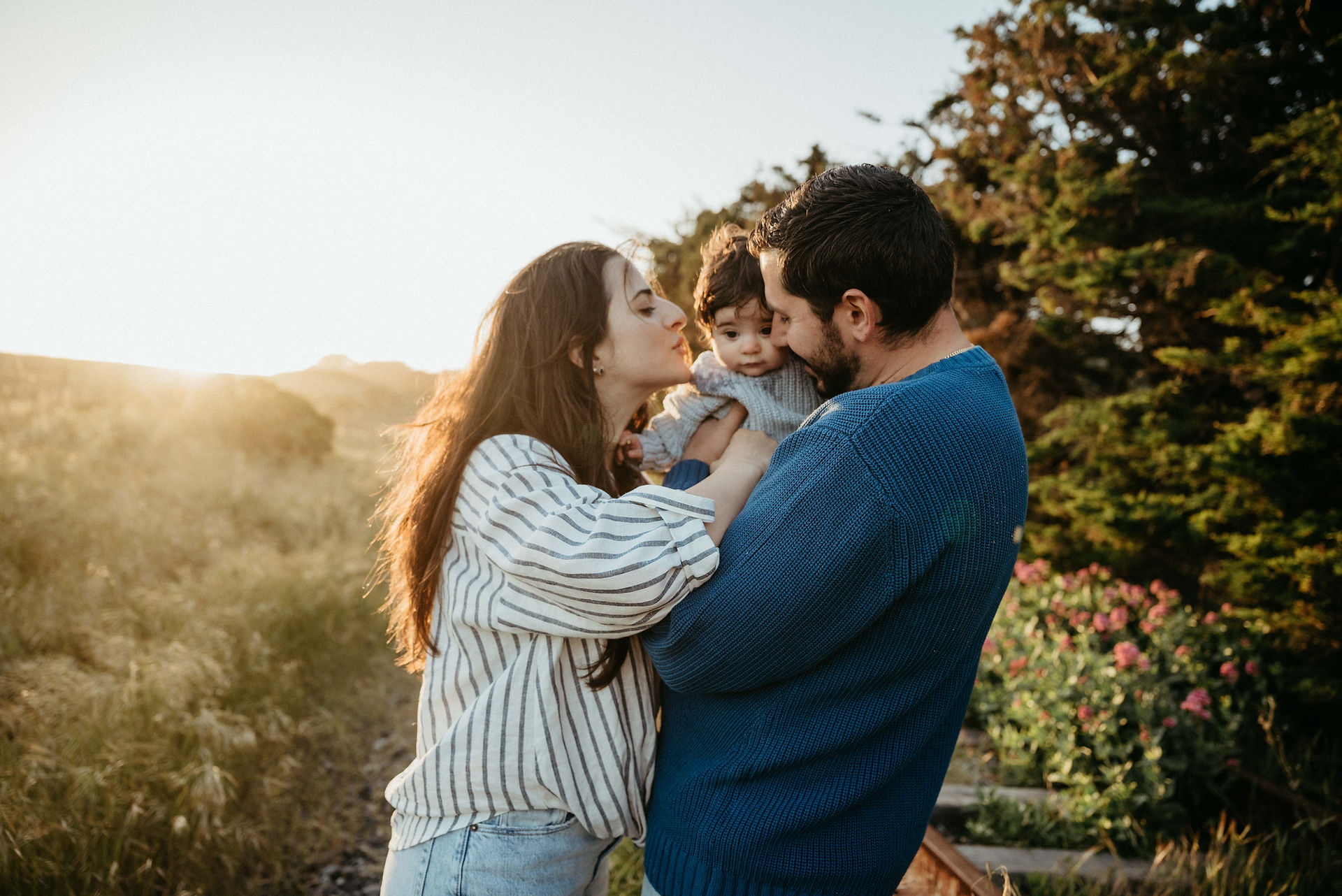 photo of mom dad and baby during golden hour at davenport beach