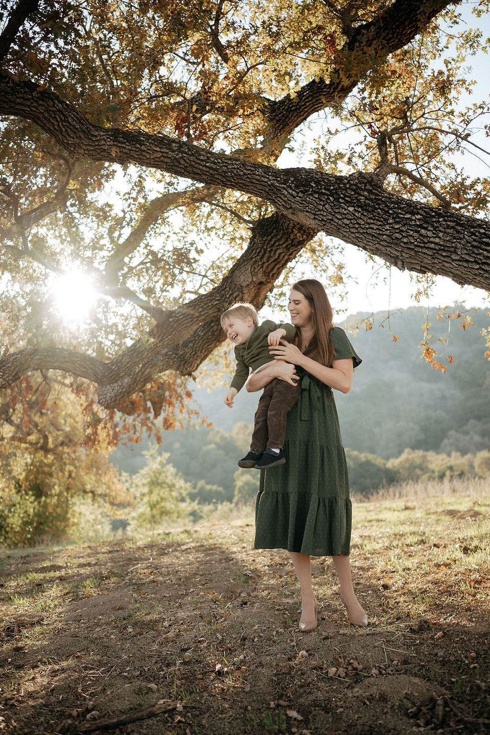 mom playfully holding toddler boy at Belgatos Park