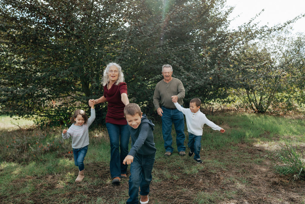 grandparents and three grandchildren at Ulistac natural preserve running while holding hands