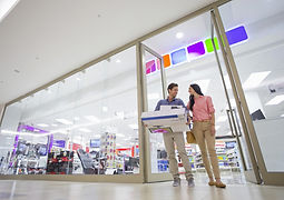 Couple leaving electronics store with boxes