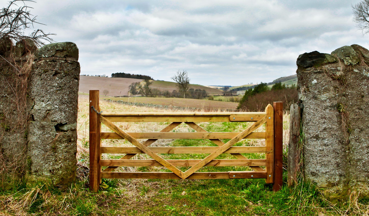 Wooden gate in a stone wall on a farm