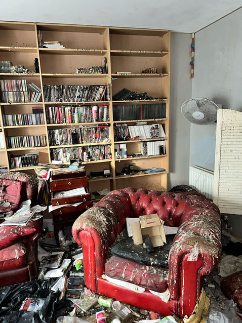 Living room full of rubbish and damaged furniture