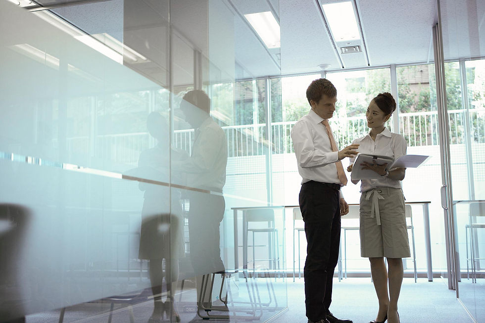 man and woman standing by a glass partition