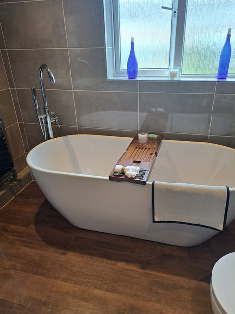 freestanding bath on wooden flooring