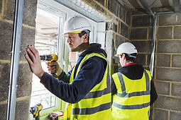 Workers installing UPVC windows in a new build