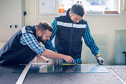 Men cutting a single pane of glass