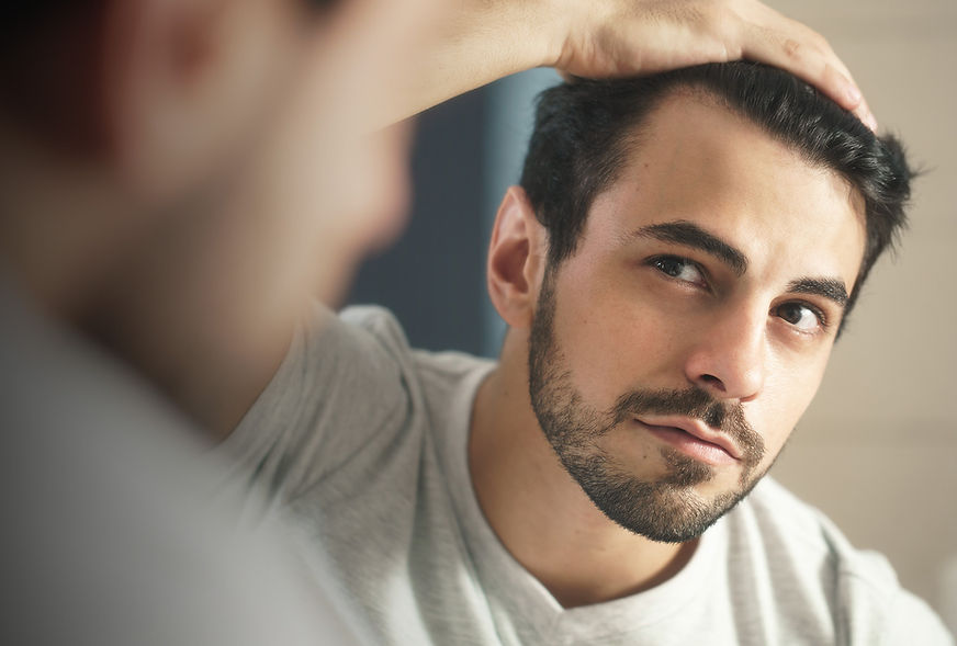 Man checking hair in mirror