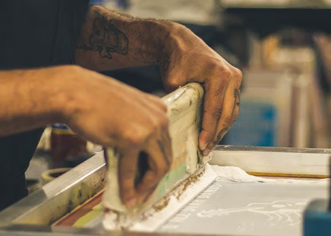 Eye-level view of a local screen printing shop with colorful t-shirts hanging