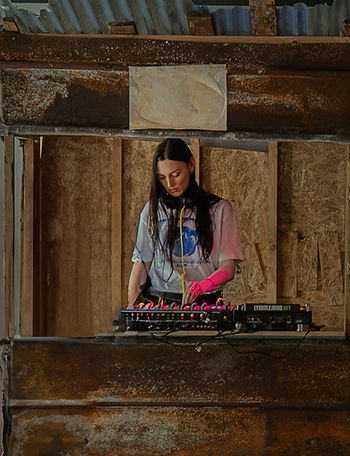 DJ playing inside a wooden cabin at the NIKE x Veneda Carter pop-up event in Copenhagen, inspired by a Polish bazar and Scandinavian minimalism.