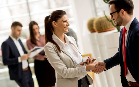 BRANDED by Focoso hostess warmly greeting a client at a professional trade show in Copenhagen