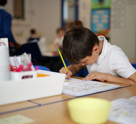 Pupil writing in a classroom