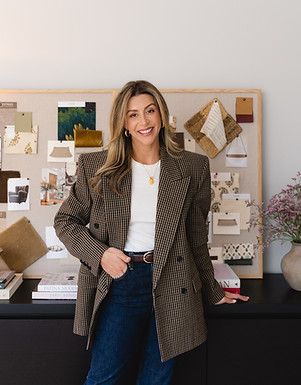 Chelsea Greenway beside a board of fabric swatches, colour samples and interior design inspiration.
