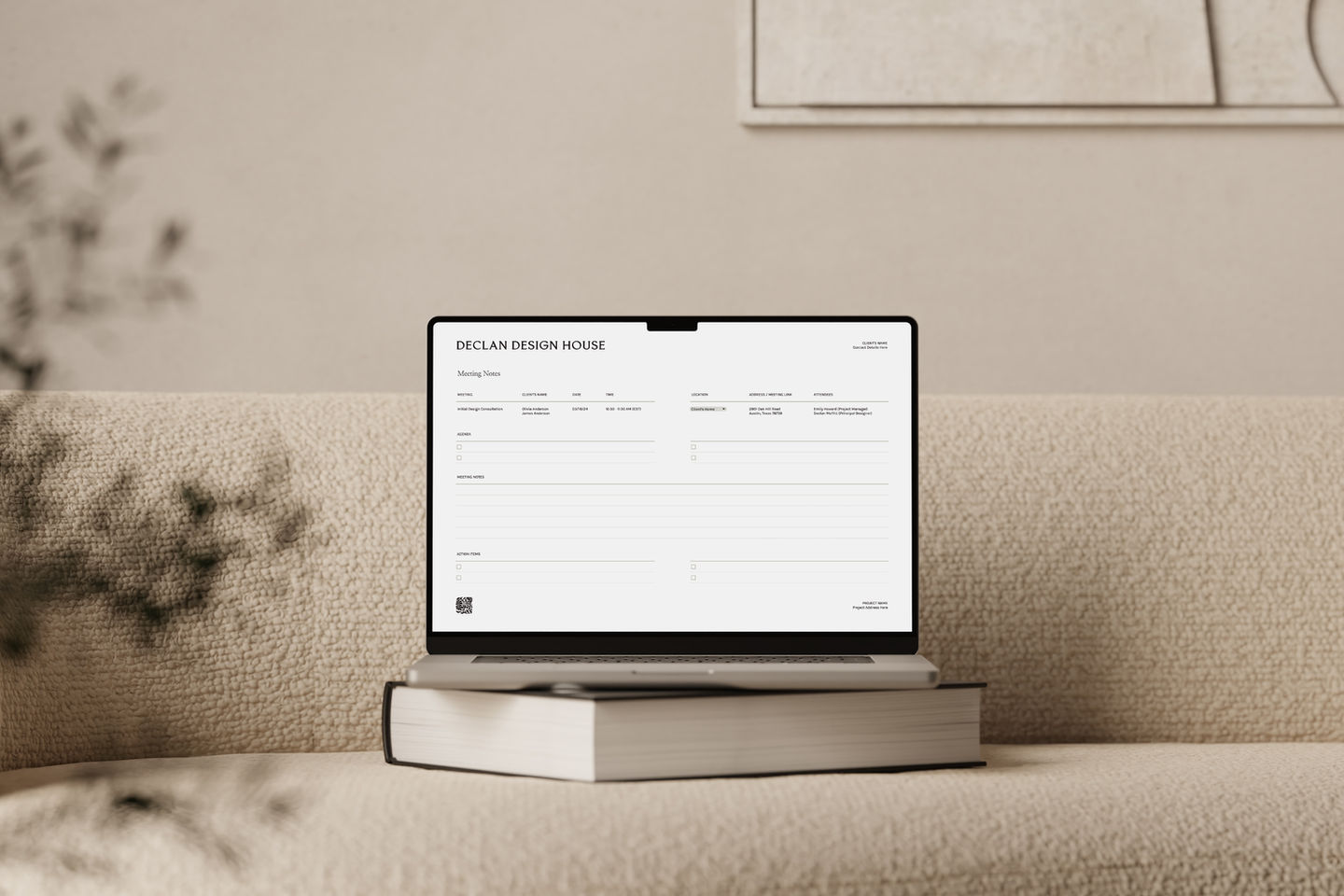 Laptop displaying a form on a neutral sofa with book and plant.